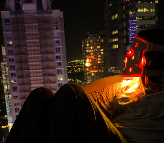 Person wearing Beautifect LED mask, looking out across NYC